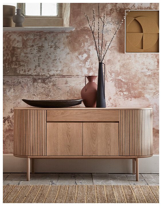 The Ercol Siena Sideboard in Oak colour set in a rustic space.