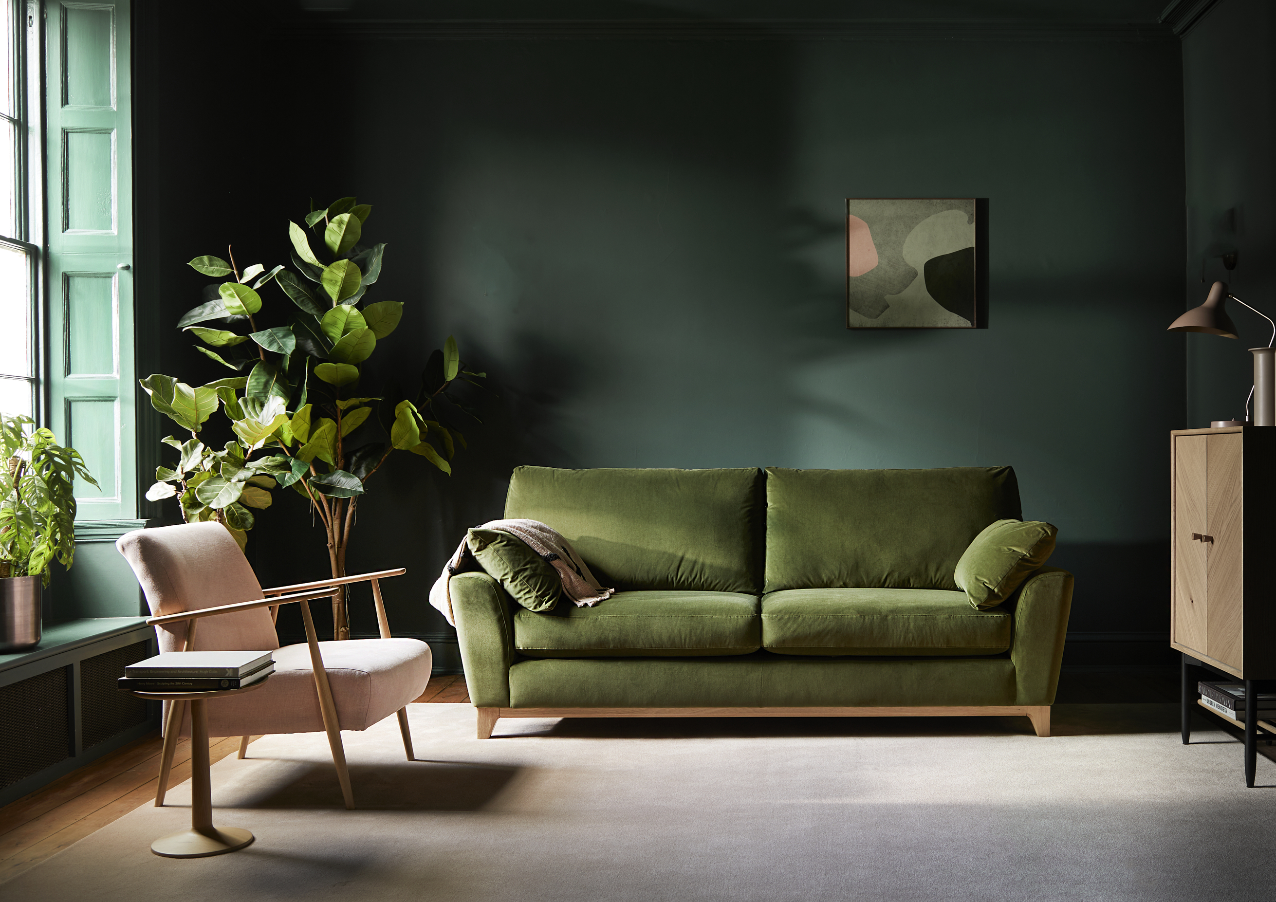 Ercol Novara Velvet Green Sofa And Marlia Dusty Pink Chair in a Green Drenched Room with Monza Tall Sideboard in The Corner