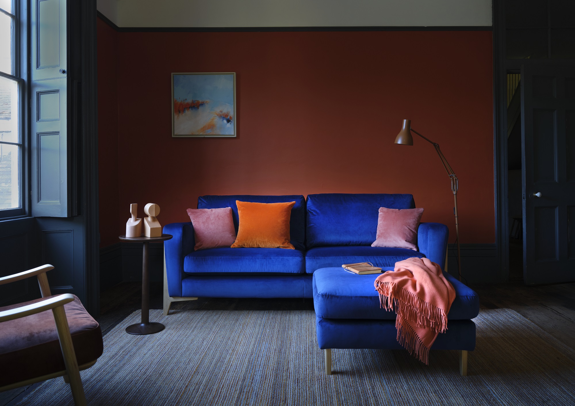 Ercol Marinello Sofa in Blue Velvet with Matching Footstool In A Colourful Living Room