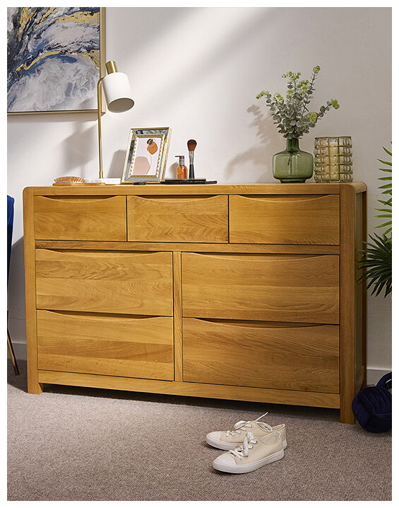 An image of the Ingrid Chest of Drawers in a wooden finish, set in a tidy living space.