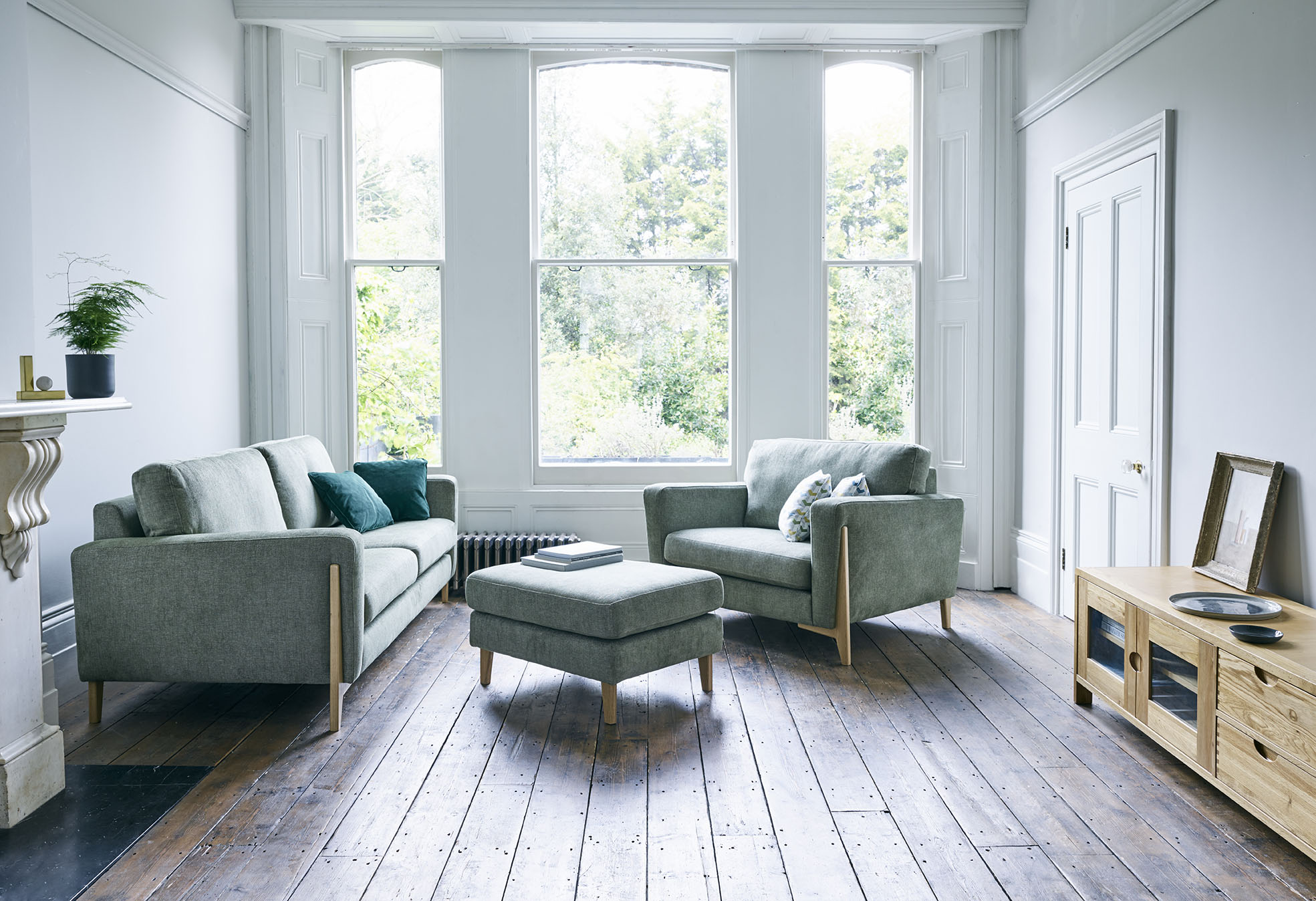 Ercol Grey Fabric Marinello Sofa, Armchair & Footstool in a Bright Livingroom with High Ceilings, Tall Windows and Wooden Flooring
