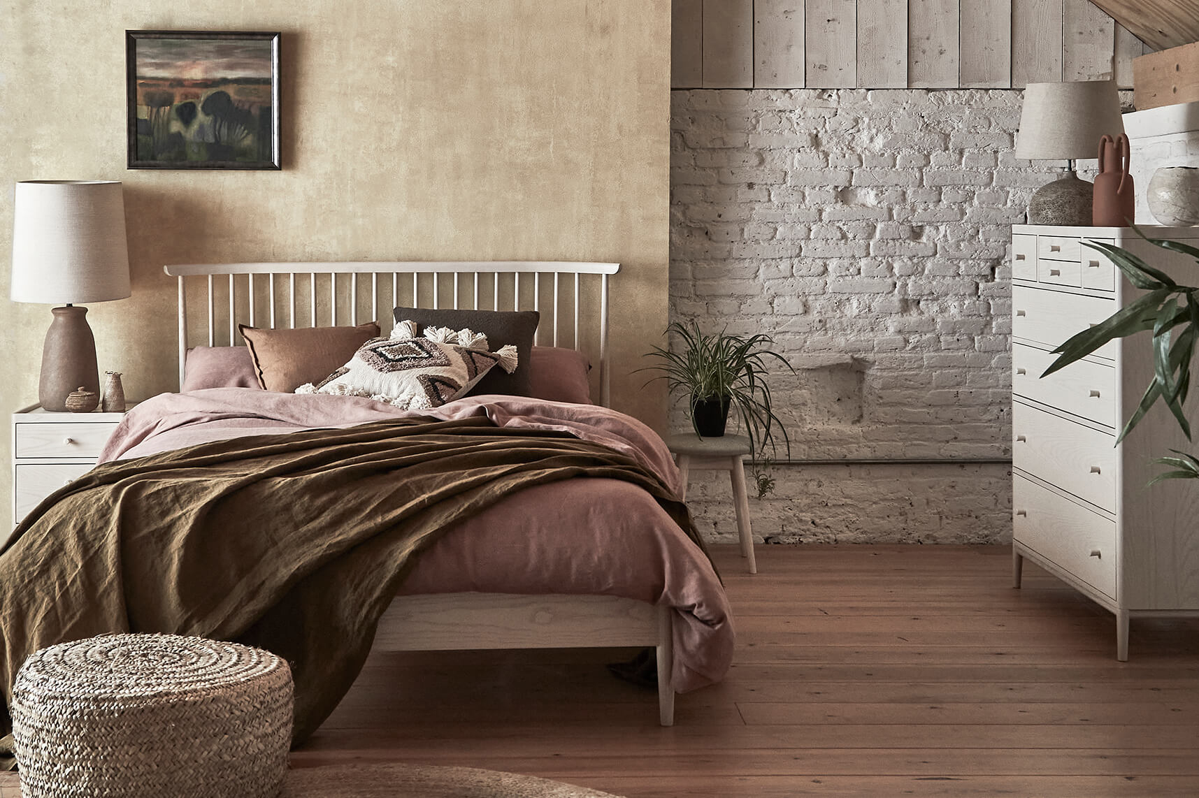 Ercol Bedframe with Dusty Pink Bedding and Olive Green Throw in a Neutral Bedroom