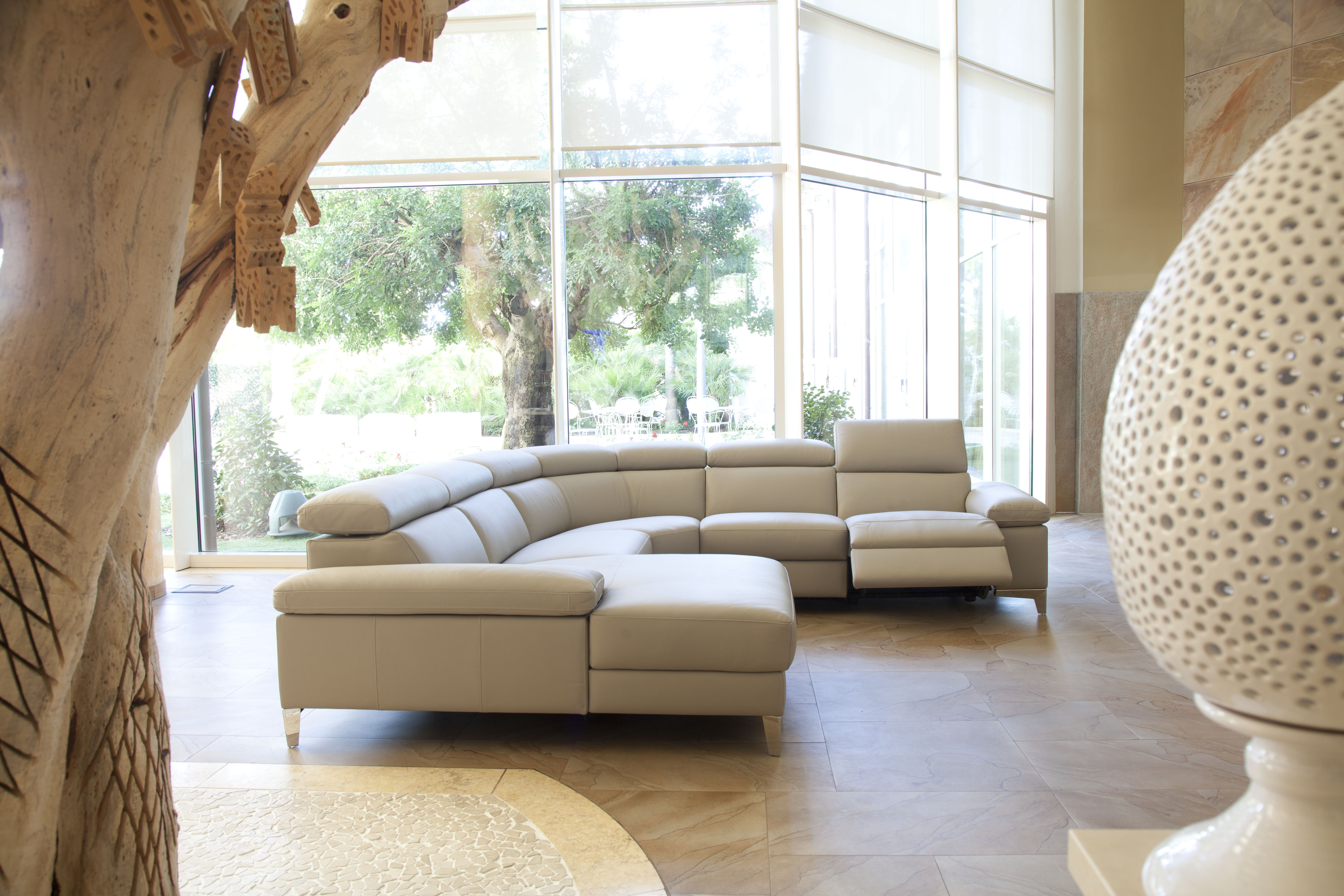 nicoletti cream leather corner sofa in a bright living room with floor to ceiling windows in the foreground