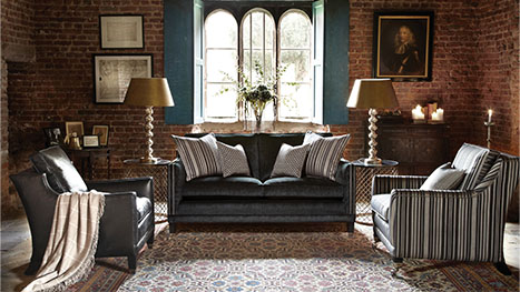 grand styled living room featuring two duresta chair and 2 seater sofa all in shades of blue in an exposed brick room